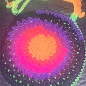 Handmade crocheted round purse with different bright colors on each side.